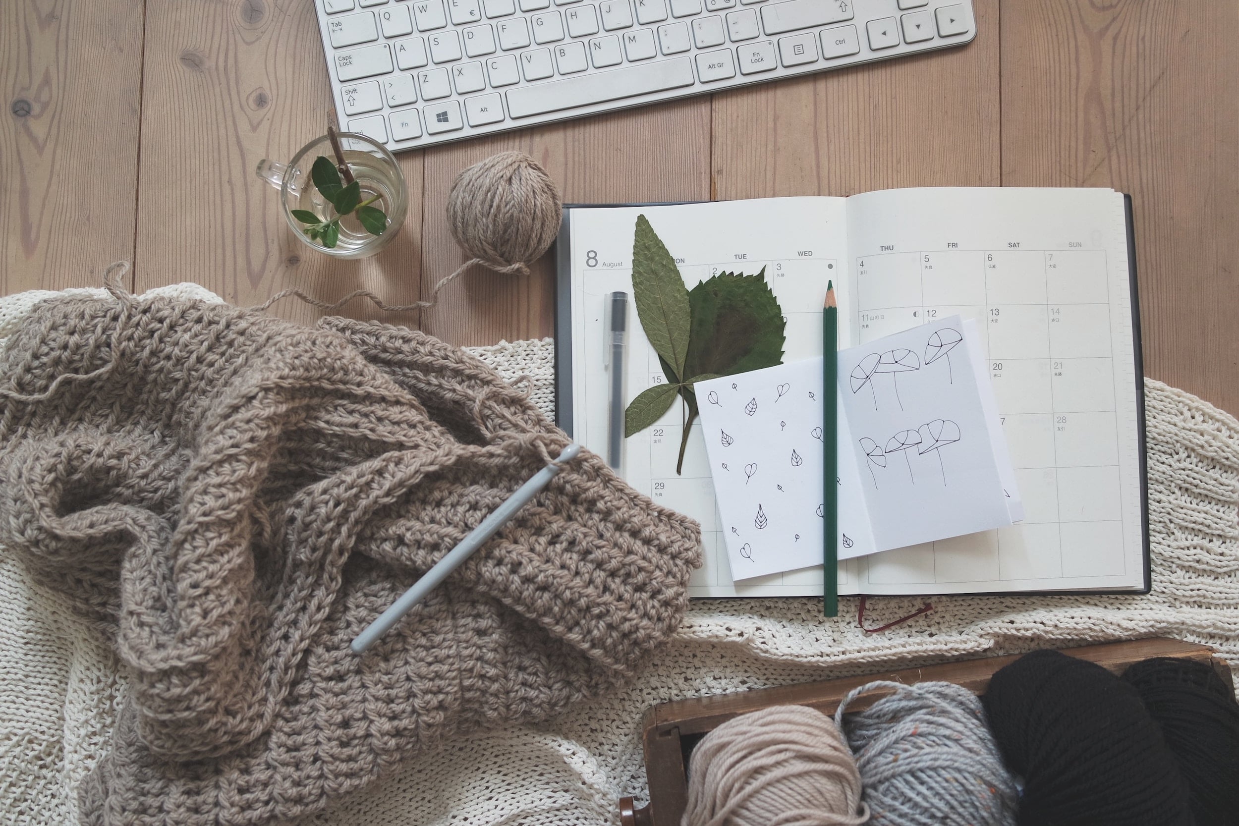 tricot en cours posé sur bureau avec cahier et clavier